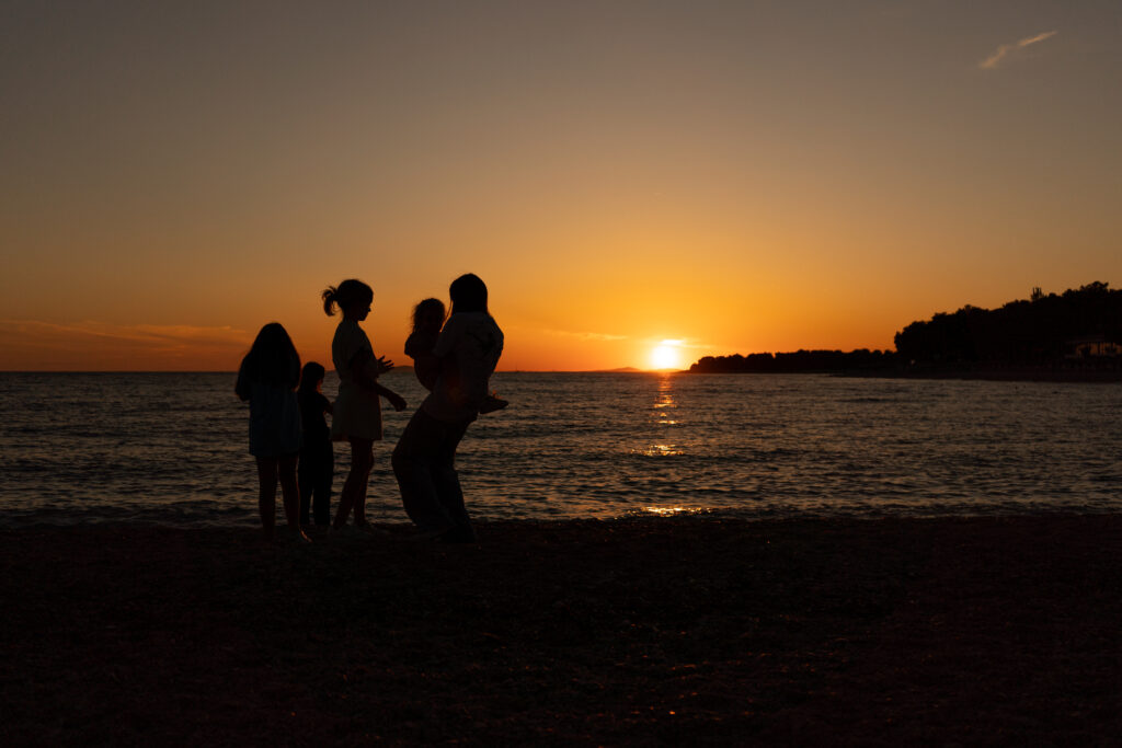 spokojená rodina u moře při západu slunce